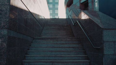 Rear view of young woman going up the stairs in the street. Shot on Red Epic Dragon