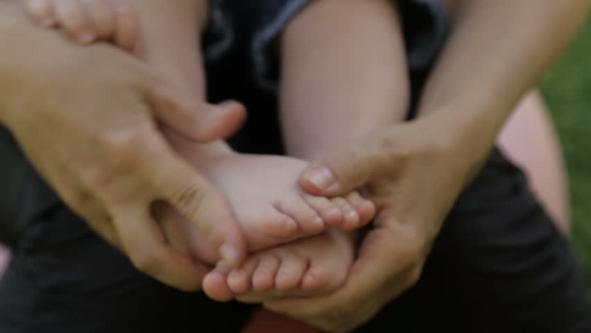 Mom holds baby's feet in hands | Shutterstock HD Video #27891670