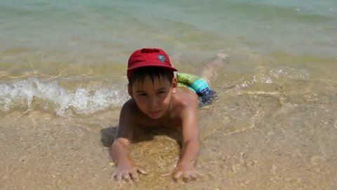 Young boy playing in the waves on the tropical sea