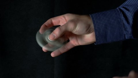 white hand spinner, or fidgeting spinner, rotating on child's hand.