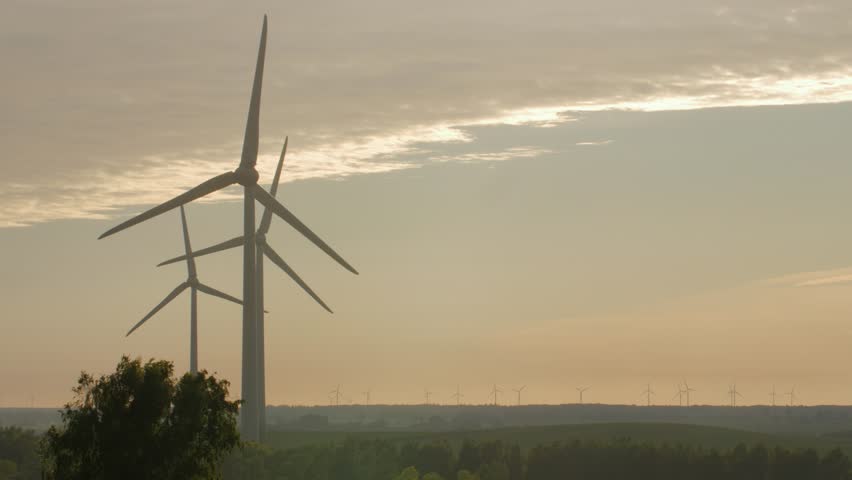 Wind turbine farm with rays of light at sunset, Europe. | Shutterstock HD Video #27905269