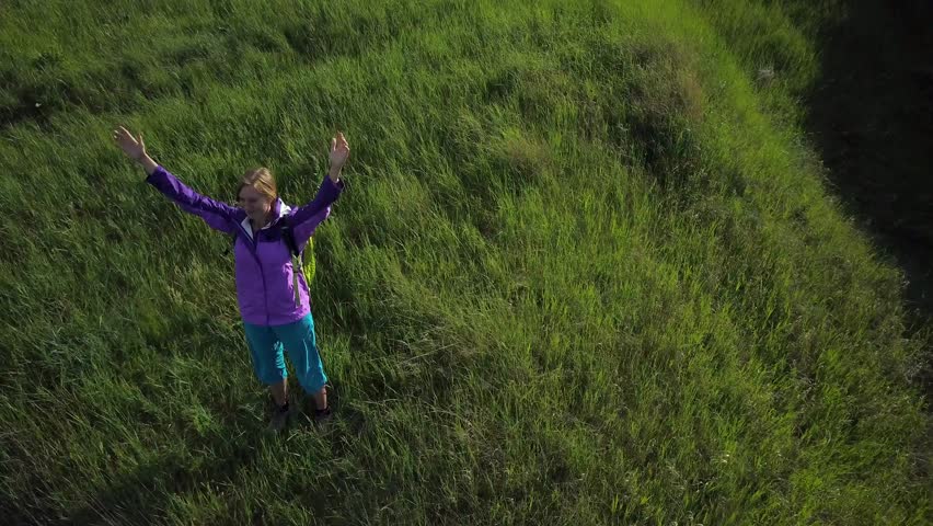 Woman enjoys hiking with a backpack over hilly terrain. Hiking. View from height
