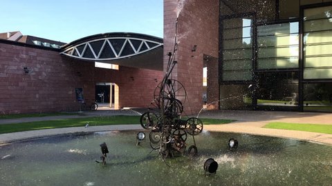 BASEL - MAY 28, 2017: A unique kinetic metal water spraying sculpture "Schwimmwasserplastik Fontaine" by the artist Jean Tinguely in the Solitudepark at Museum Tinguely in Basel, Switzerland. Yeh 