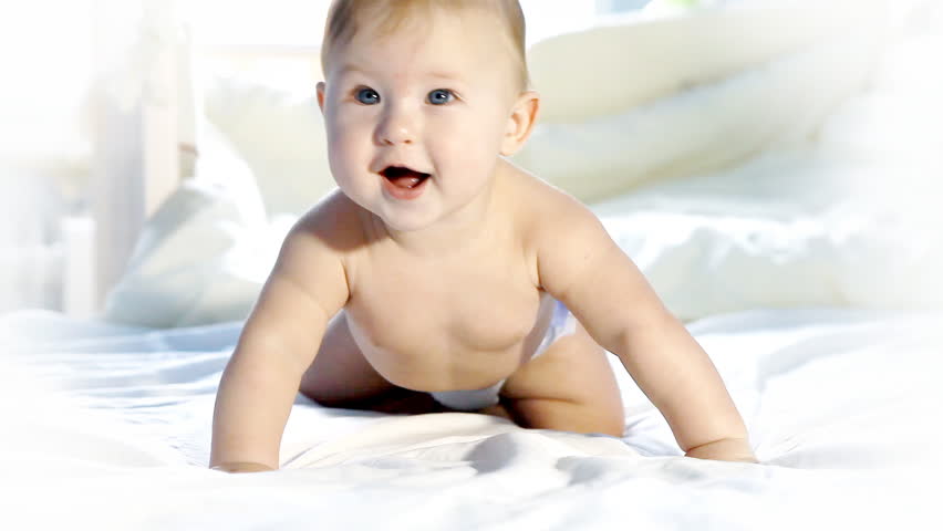 Happy baby having fun on the bed