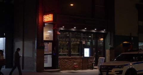 A nighttime exterior establishing shot of a bar and restaurant in downtown Manhattan, New York City.	 Day Night matching available. 