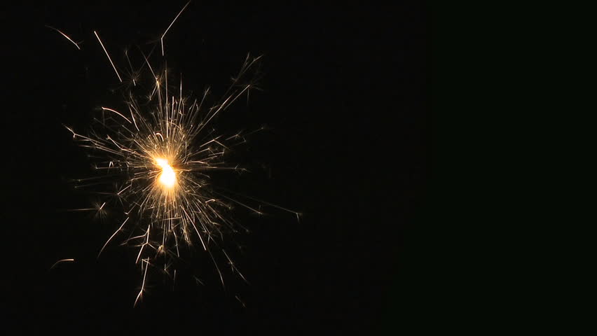 Sparkler. A bright fizzing sparkler on crushed black background. HD 25p