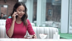 Young charming woman calling with cell telephone while sitting alone in cafe