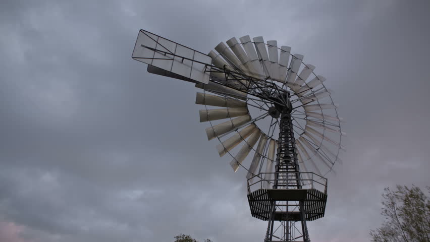 Time lapse vintage wind turbine and clouds passing by 