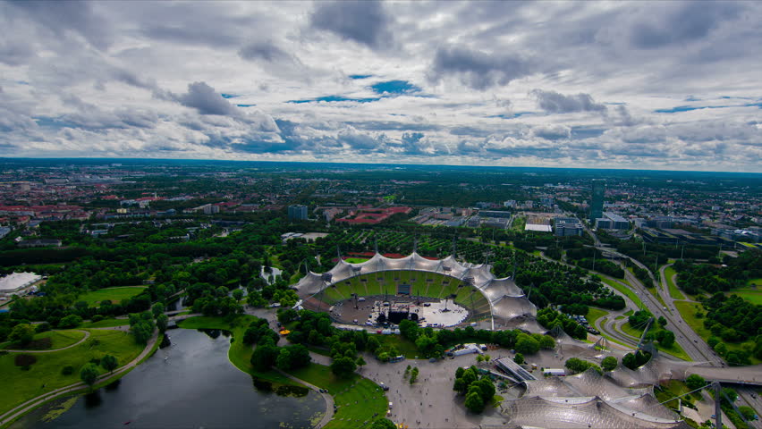 Olympiastadion Munich, Bavaria, Germany. Timelapse view with large cloudy mountains. 