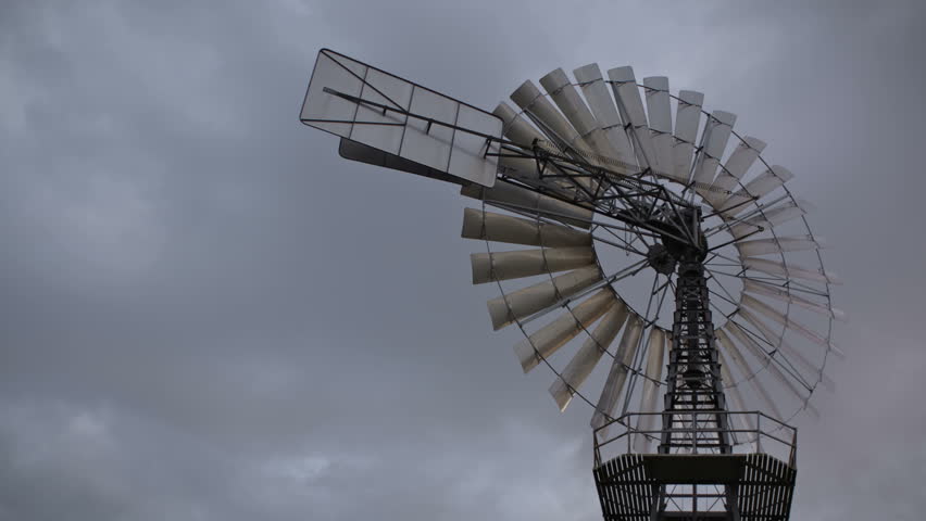 Time lapse vintage wind turbine and clouds passing by 