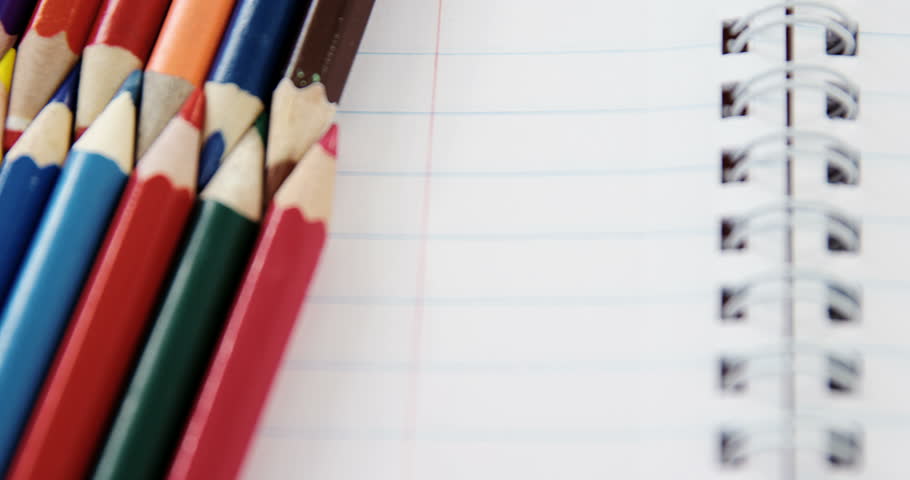 Close-up of colored pencils arranged in interlock pattern on white background