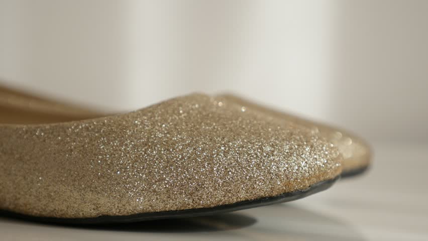 Elegant golden sparkling shoes 4K 2160p 30fps UltraHD footage - Tilting on ballet flats on white background close-up 3840X2160 UHD video