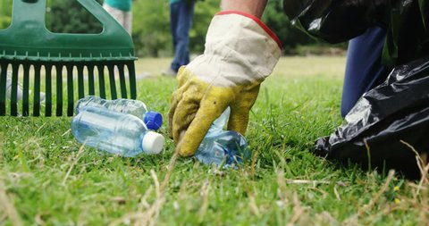 Close-up of volunteer collecting litter in park