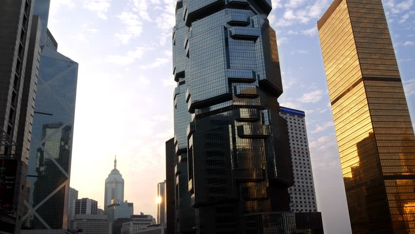 Hong Kong central Queensway skyline upwards view black and gold windows, with Lippo tower, Bank of China tower and distant The Center at sunset with clouds moving across sky