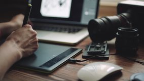 Woman designer working at a laptop with a graphics tablet. The view from behind shoulder, close-up, sliding shot - Powered by Shutterstock - Get 15% off with code: PIKWIZARD15