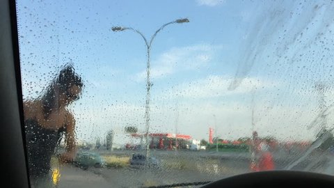 Beautiful woman washing car with pistol pressure