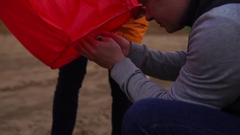 Man igniting the candle in sky lantern. Preparation of launching of the sky lantern. Adlı Stok Video