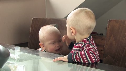 little boy hitting his twin brother in the face child starts crying and punches back
