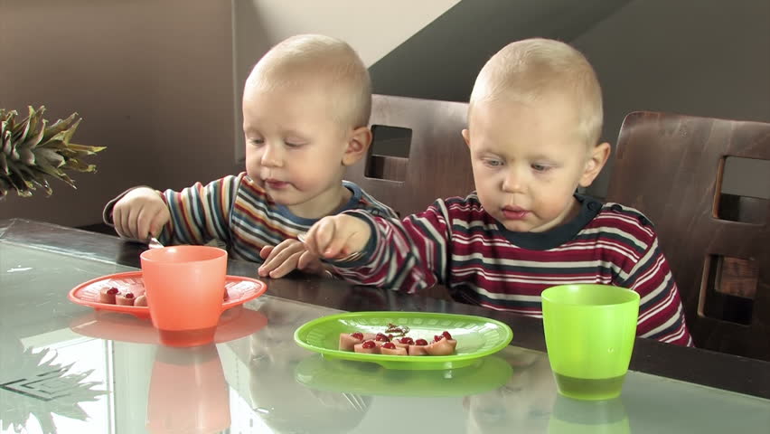 clumsy twin boys eating sausage with catchup for breakfast
