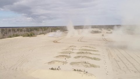 Tanks travel through the sand and shoot