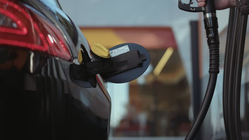 Multiple shots of a gas pump inserted in car tank. Slow motion. Royalty-Free Stock Footage #27973300