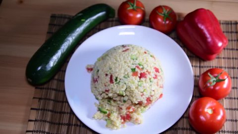 Bulgur also burghul with vegetables. Flat view of bulgur. Tomatoes on the table. Low DOF.