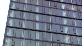 Exterior establishing shot of a New York City style glass office building day time DX 4K video. Blue sky reflection in windows