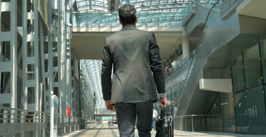 A young handsome businessman (student) in a suit, comes with a briefcase, at the station, at the airport. Concept: a new business, traveling the world, communication, contacts, a new deal, success.
 Royalty-Free Stock Footage #27992323