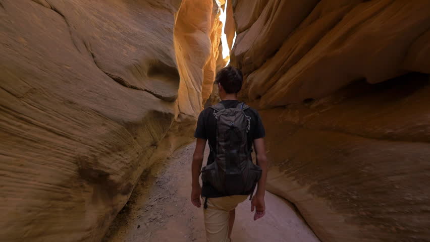 Glide camera follows teenage boy hiking through Bull Valley Gorge desert, red-rock slot canyon in the Grand Staircase Escalante National Monument in southern Utah.  | Shutterstock HD Video #27993133