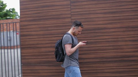 A man walks through the city and uses a smartphone
