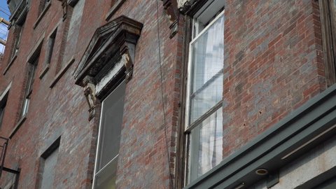 Close up exterior DX establishing shot of old vintage architecture style apartment building window day time outside. Brooklyn tenement style architecture design construction
