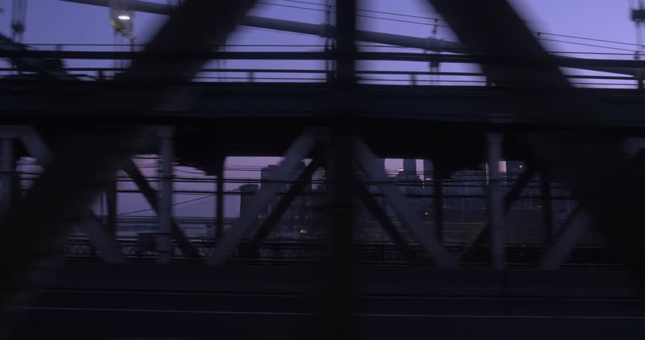 A passenger's side view background plate looking out the window of a subway car as it passes over the Manhattan Bridge. The New York City skyline at dusk is seen in the distance.  	