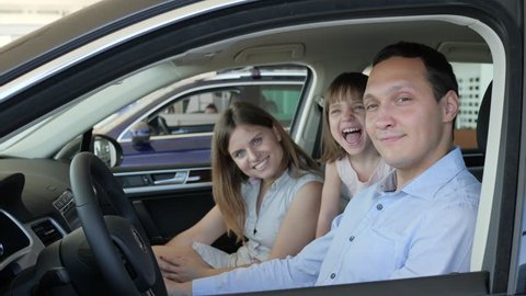 family in car center, joy of buying automobile, portrait of happy people sitting in new vehicle