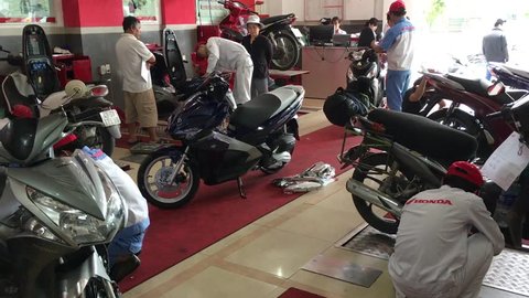 DA NANG, VIETNAM - NOVEMBER 9, 2016: An unidentified man repairs a motorcycle at a Honda service center.