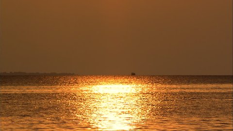 Boat passes sunset
