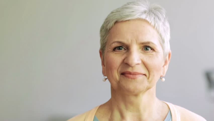 people, emotion, expression and portrait concept - happy laughing senior woman face