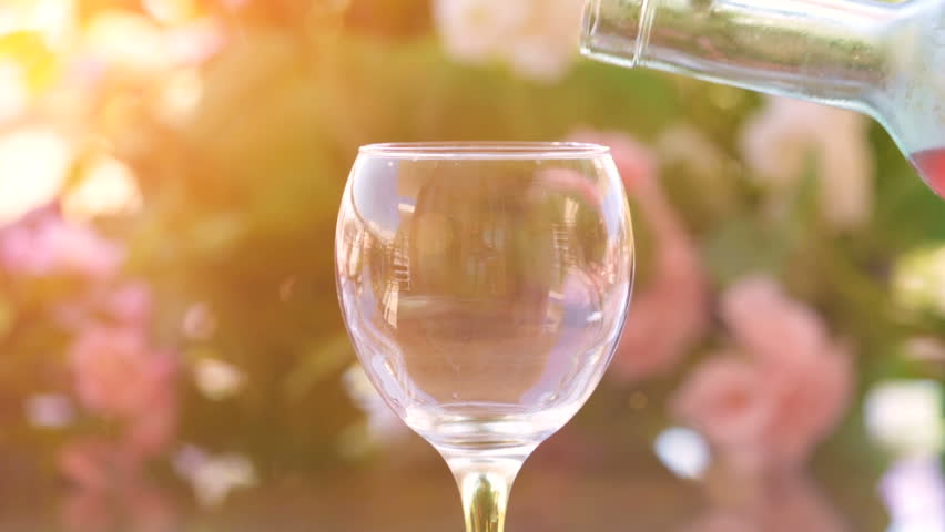 Pouring a glass of cold rose wine, green garden background Royalty-Free Stock Footage #28023433