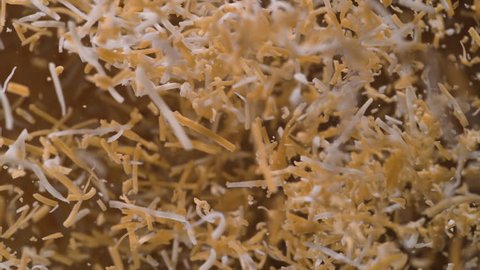 Shredded cheddar cheese flies after being exploded. Shot with high speed camera, phantom flex 4K. Slow Motion.