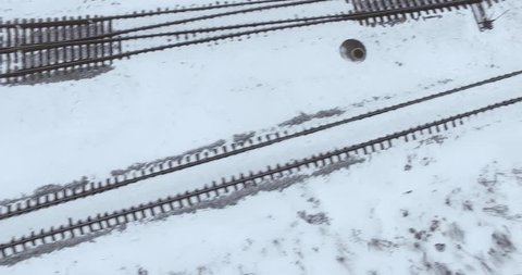 Railroad track top view. Aerial view of empty railroad in winter time. Flying over countryside on a cold snowy winter day.
