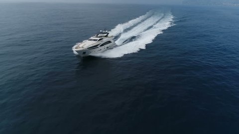 Aerial view of a luxury yacht navigating fast at open sea
