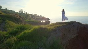 Feminine romantic girl make beautiful motion on top coast sunrise drone footage