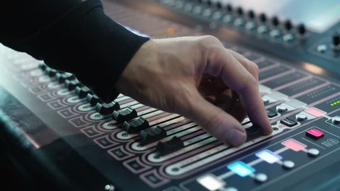 Man working on professional digital audio channel mixer in studio. Electronics for amplifier and balance of sound in show. Soundboard knobs. sound engineer presses the keys, moves the buttons. Closeup