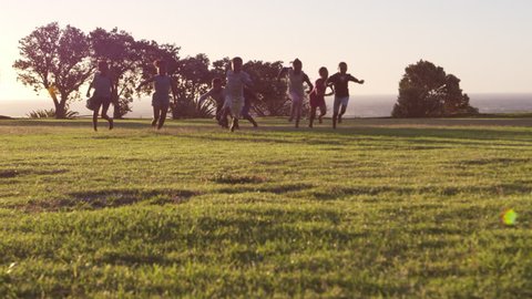Elementary school kids playing with a football in a field