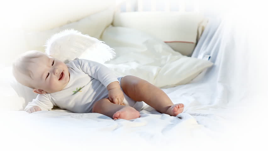 Happy baby has fun on the bed