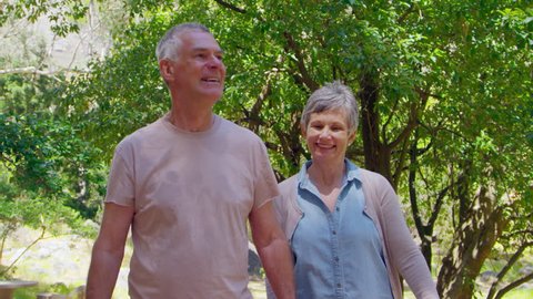 Mature Couple Walking Along Forest Path Together