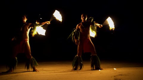 Polynesian male Fire dancers performing with spinning flaming torches a traditional dance culture in tropical French Polynesia South Pacific
