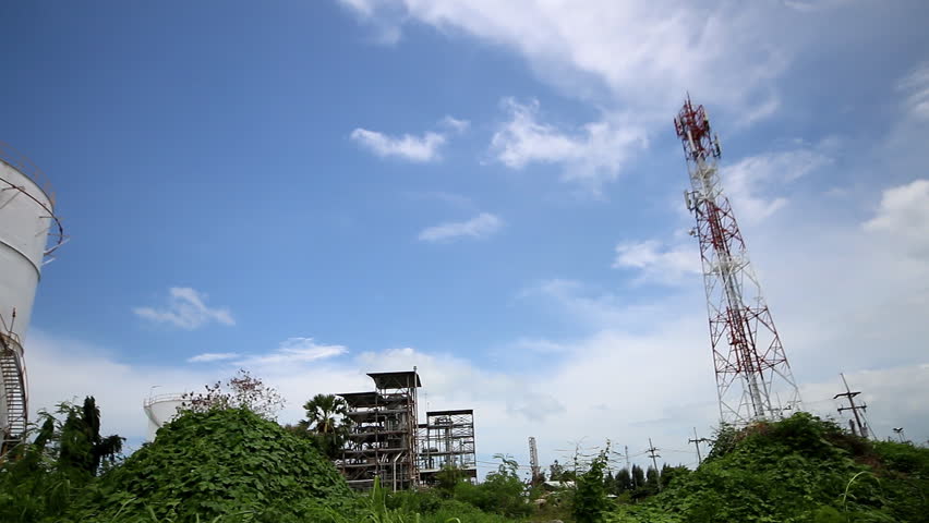 Vertical large oil tank in petroleum refinery plant with cloudy sky background