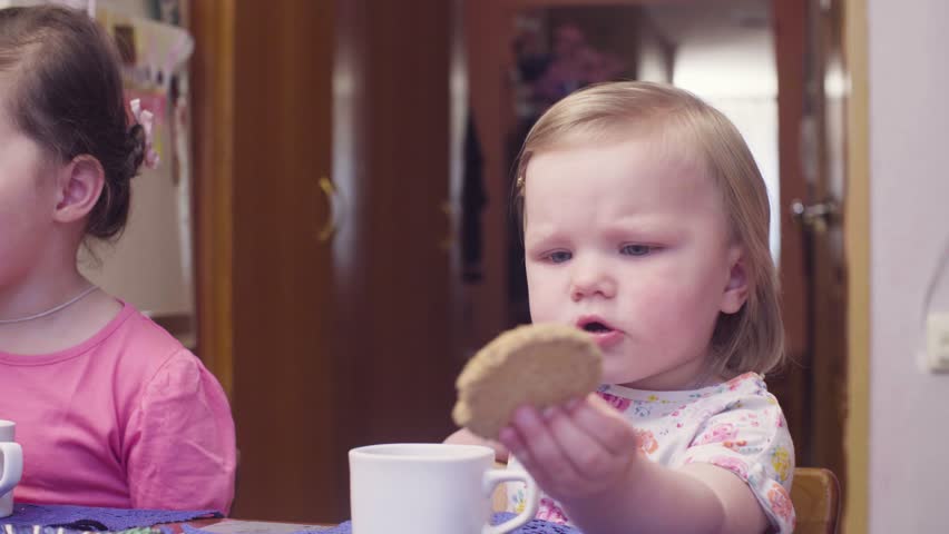 Little baby girl eating cookies