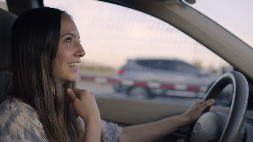 Slow Motion Shot Of Happy Road Tripper Driving On Freeway, Semi Truck Passes Her  Royalty-Free Stock Footage #28065727
