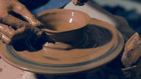 Close up on artisan's hands forming clay bowl
